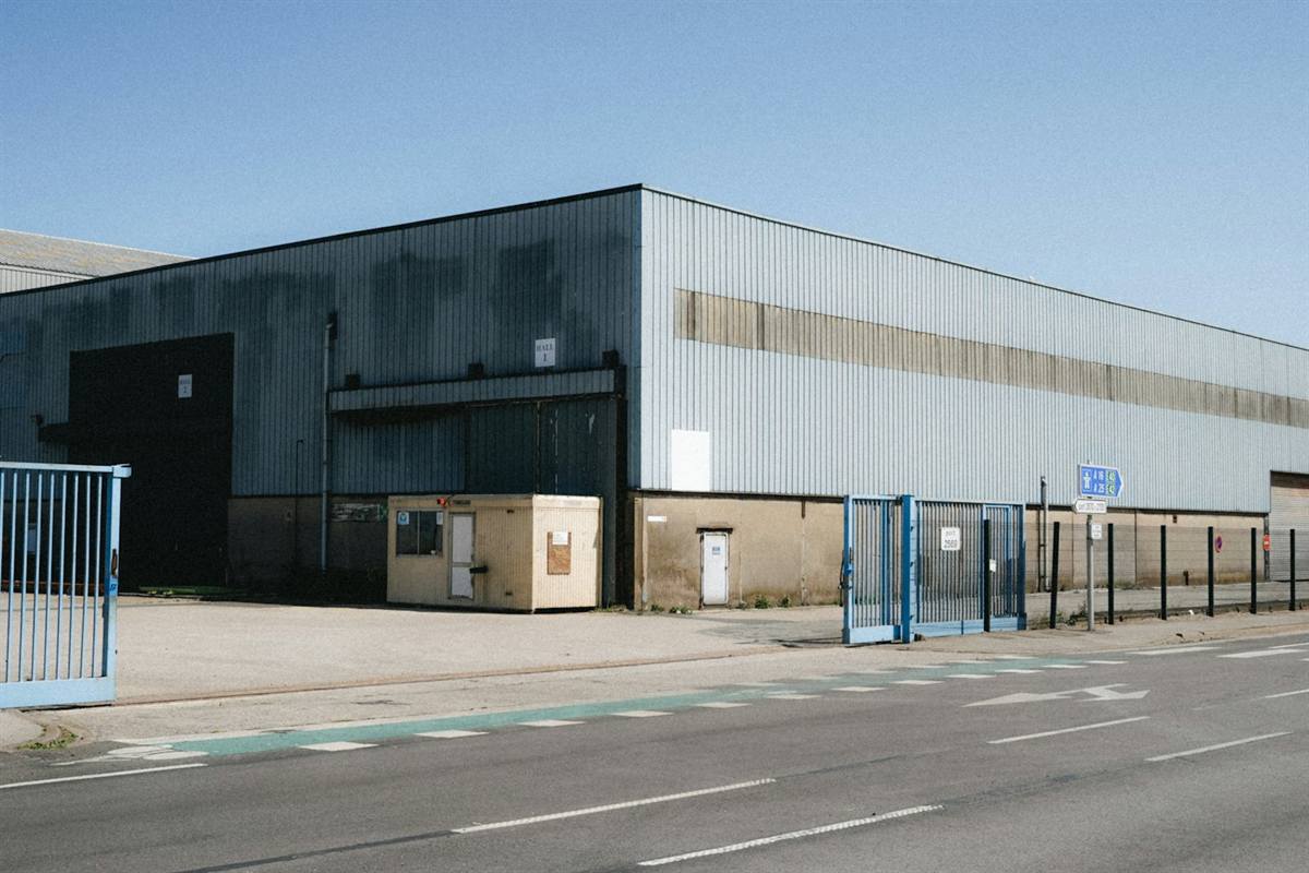 Large industrial warehouse building with a wide access road